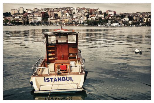 Postcard from Istanbul. Motor boat by the Golden Horn - Istanbul, Turkey. The Beyoglu district in the background.