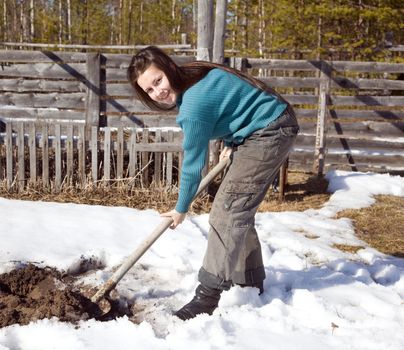A young girl digs the garden in early spring. Russia. The extreme north.