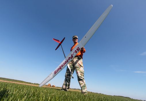 Man holds the RC glider, wide-angle