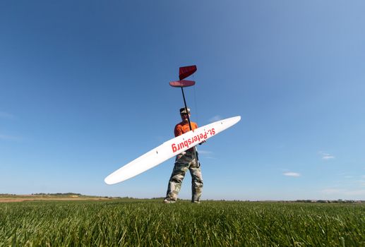 Man holds the RC glider, wide-angle