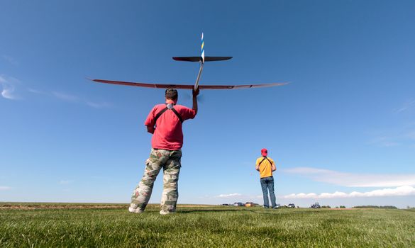 Man launches into the sky RC glider, wide-angle