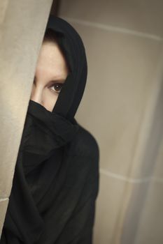 Cautious Islamic Woman in a Window Pane Wearing Traditional Burqa or Niqab.