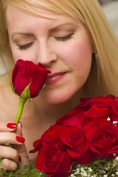 Beautiful Woman Smelling a Bunch of Red Roses.