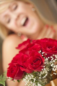 Surprised Attractive Blonde Woman Accepts Gift of Red Roses.