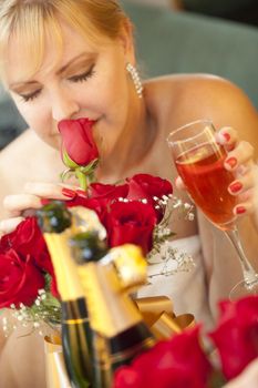 Attractive Blonde Woman Smells Roses at Mirror Near Champagne.