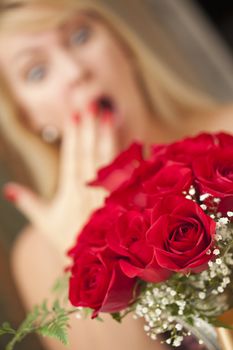 Surprised Attractive Blonde Woman Accepts Gift of Red Roses.