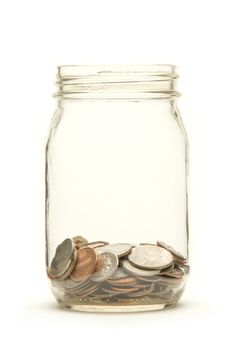 American coins in a glass jar against a white background