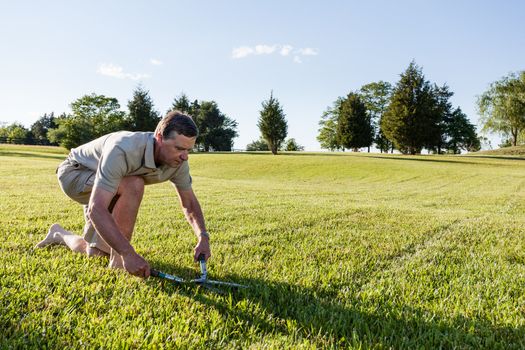 Challenging task of cutting large lawn with grass shears by hand