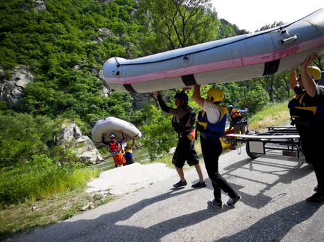 Group of people carrying boats for whitewater rafting