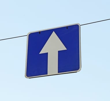 A road sign one-way traffic above the road