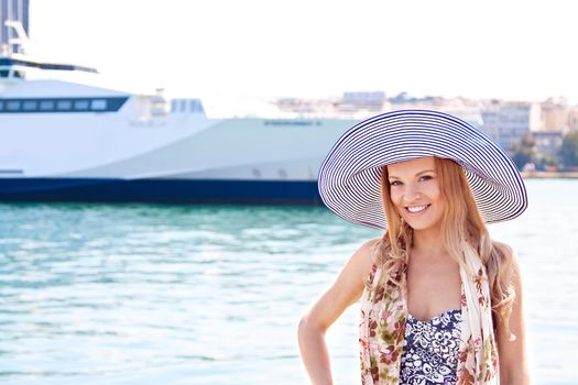 Portrait of a young and beautiful girl in the background of a large ocean liner