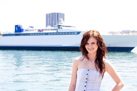 Portrait of a young and beautiful girl in the background of a large ocean liner