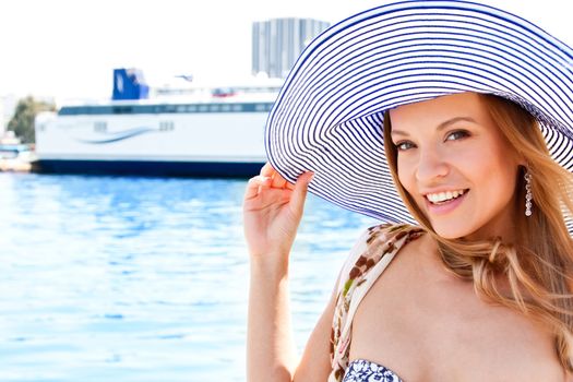 Portrait of a young and beautiful girl in the background of a large ocean liner