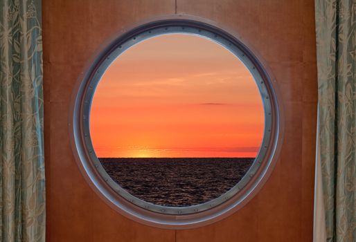 View of a sunrise through a cruise ship porthole.