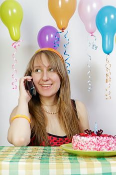 Birthday. Lucky girl talking on the phone at the holiday table