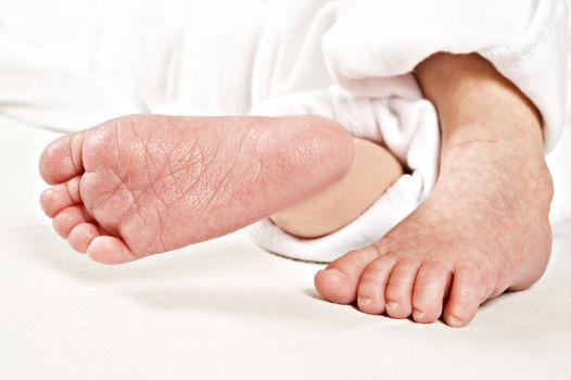 Feet of a new born baby on white