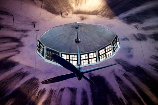 The big fan rotates under a ceiling of a building