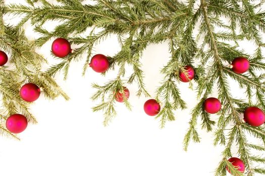 Border of red christmas garland with baubles and ribbons on white.