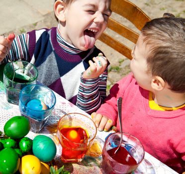 Two sweet little boys painting Eatser eggs playing