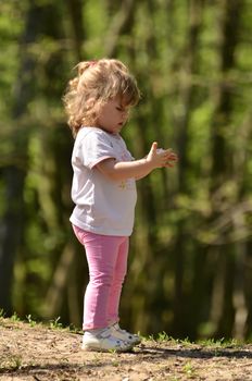 Photo shows the little girl who found bird feathers and tries to read it. (3)