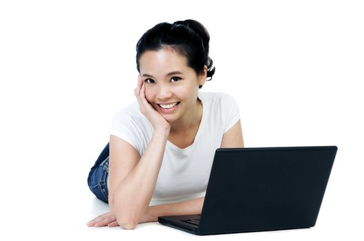 Portrait of a beautiful Asian woman lying on floor with laptop over white background.