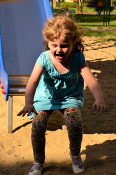 The photograph shows little girl on the slide.