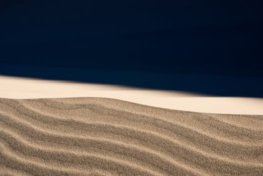 Stormy winds blow the fine sand on desert dunes