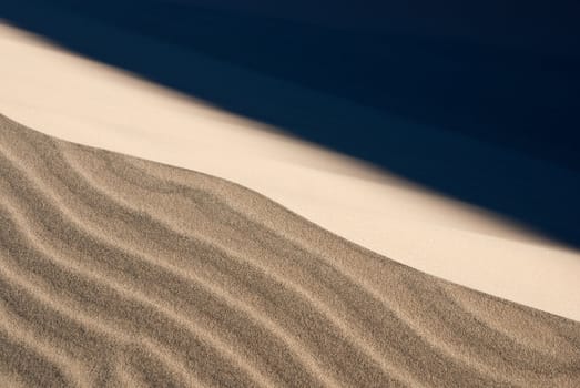 Stormy winds blow the fine sand on desert dunes