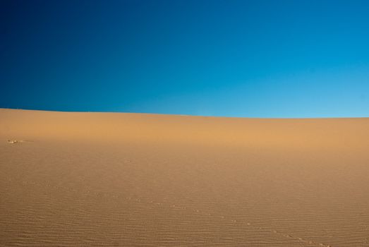 Horizon where blue sky meets sand desert