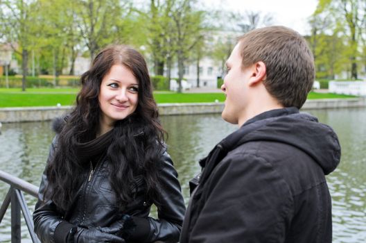 Girl and guy near the pond in the park