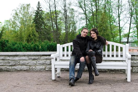 Portrait of happy couple on park bench.