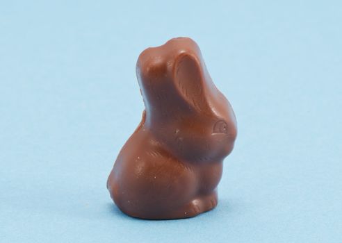 Chocolate bunny Easter symbol on blue background.