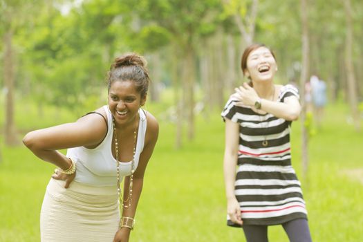 Two different races woman laughing, black and asian.