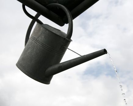 metal watering can flowing water