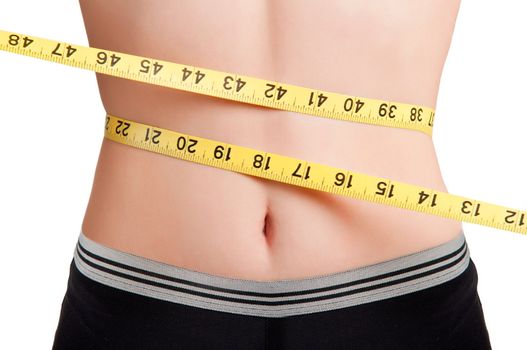 Woman measuring her waist with a yellow measuring tape