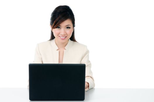 Attractive Asian businesswoman using laptop against white background.