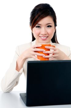 Portrait of a beautiful young businesswoman holding coffee cup at office desk over white background.