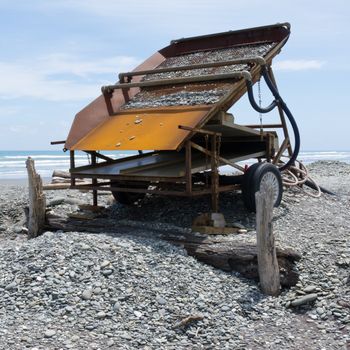 Metal sluice box on placer mining claim for extracting alluvial gold dust from gravel beach of West Coast of New Zealand South Island