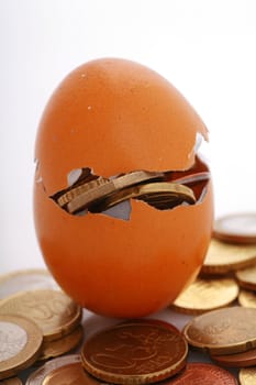 coins in an eggshell, metaphor for financial savings,fragile financials,...........
