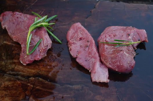 deer meat on bbq flagstone with rosemary