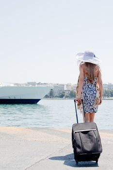 Portrait of a young and beautiful girl in the background of a large ocean liner