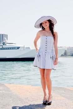 Portrait of a young and beautiful girl in the background of a large ocean liner