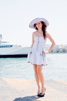 Portrait of a young and beautiful girl in the background of a large ocean liner