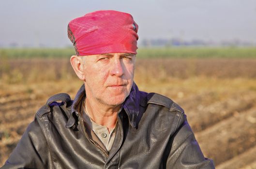 Landscape portrait of stern faced Caucasian with bandana ina USAAF pilots leather jacket