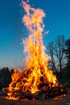 walpurgis night burning wood and religion cross with huge flames