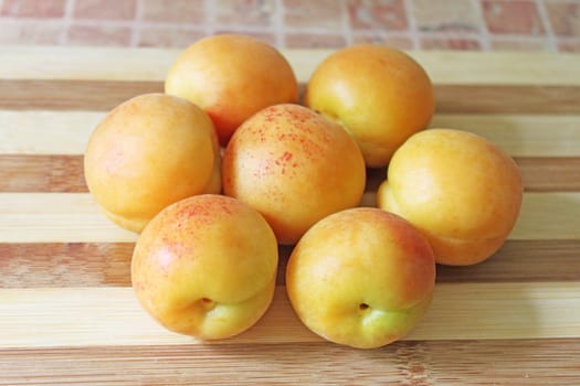heap of apricots on a wooden board
