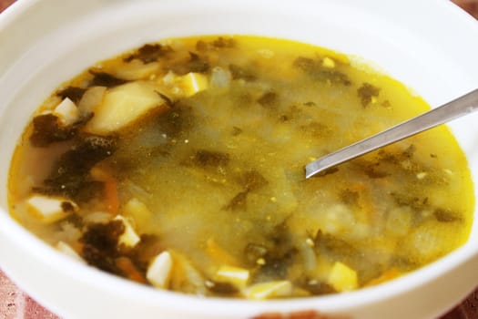 plate of soup with sorrel and eggs