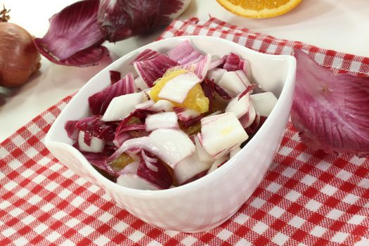 a bowl of chicory salad with shallots and orange