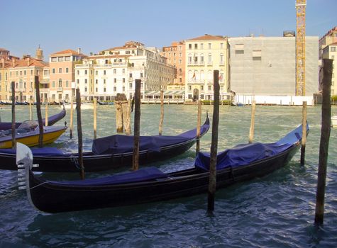 Gondolas tied to docks along the Grand Canal in Venice, Italy.