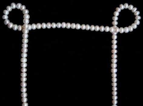 White pearls on the black velvet background 